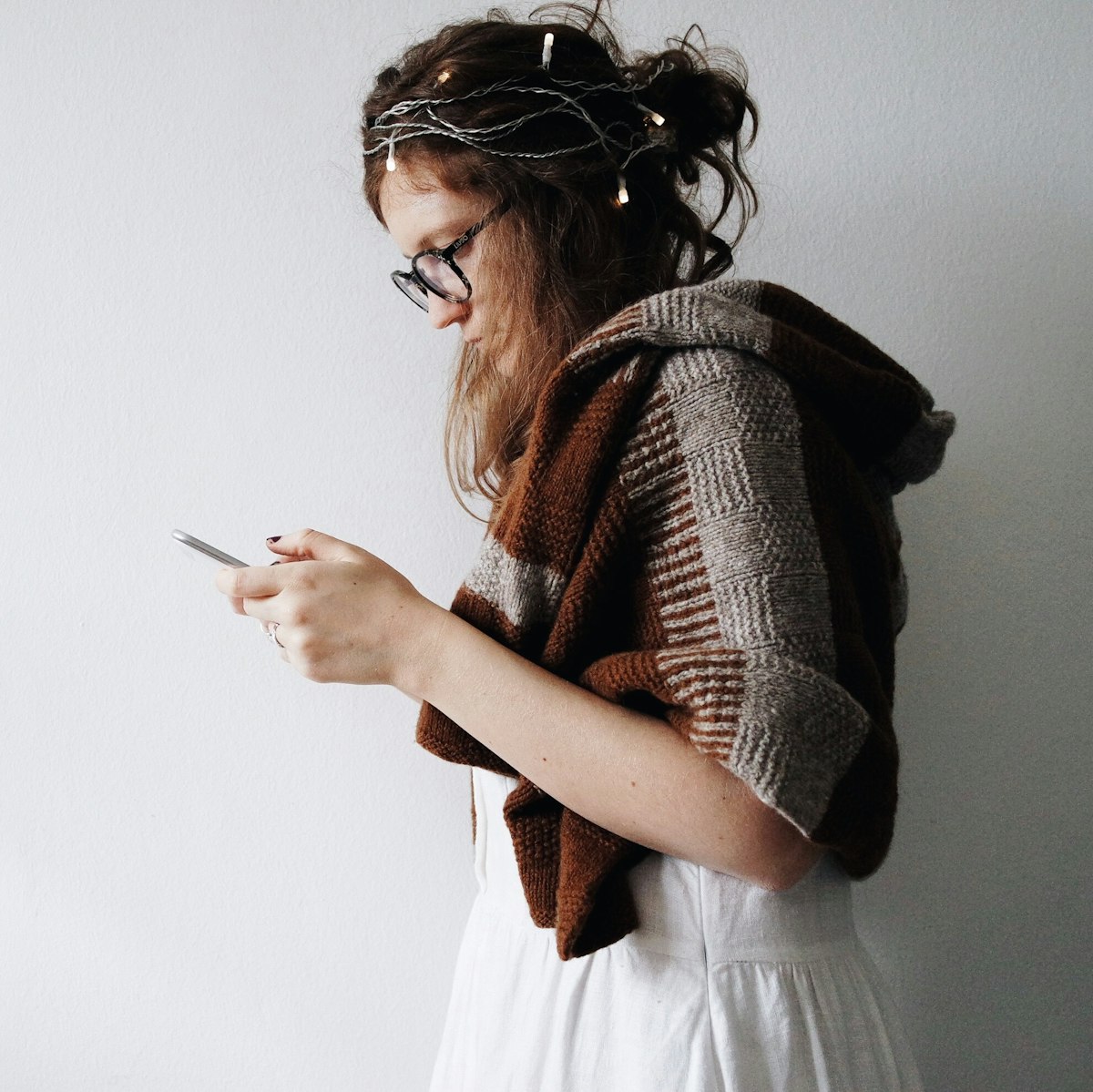 A woman looking at her phone with a calm, reflective expression